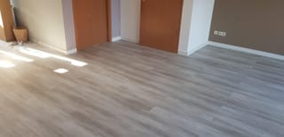 Fertig verlegter Vinylboden in heller Holzoptik in einem leeren Wohnraum